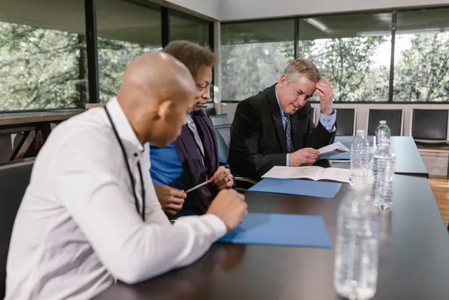Group of diverse colleagues in a business meeting reviewing documents indoors. Proceskortlægning i SMV'er: metode til at finde flaskehalse